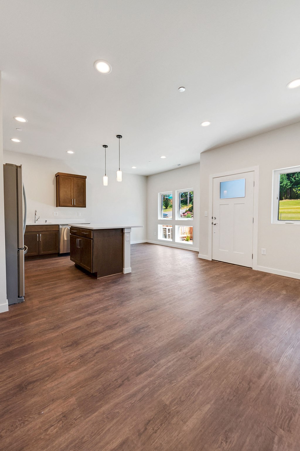 a kitchen and living room with wood floors and white walls