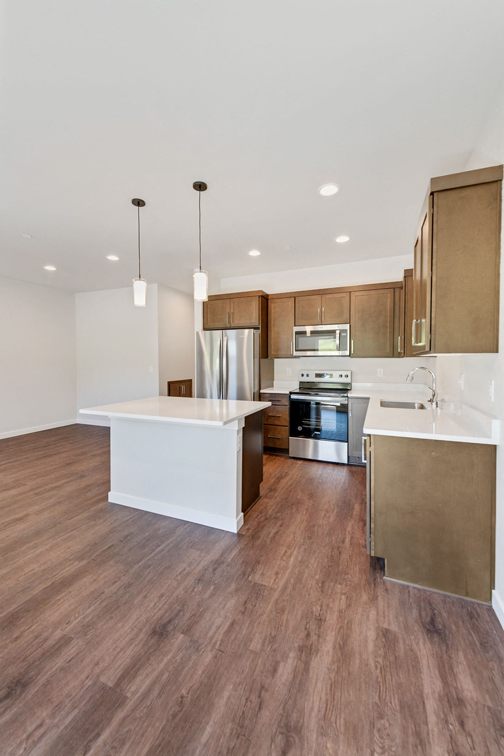 a large kitchen with wood flooring and stainless steel appliances