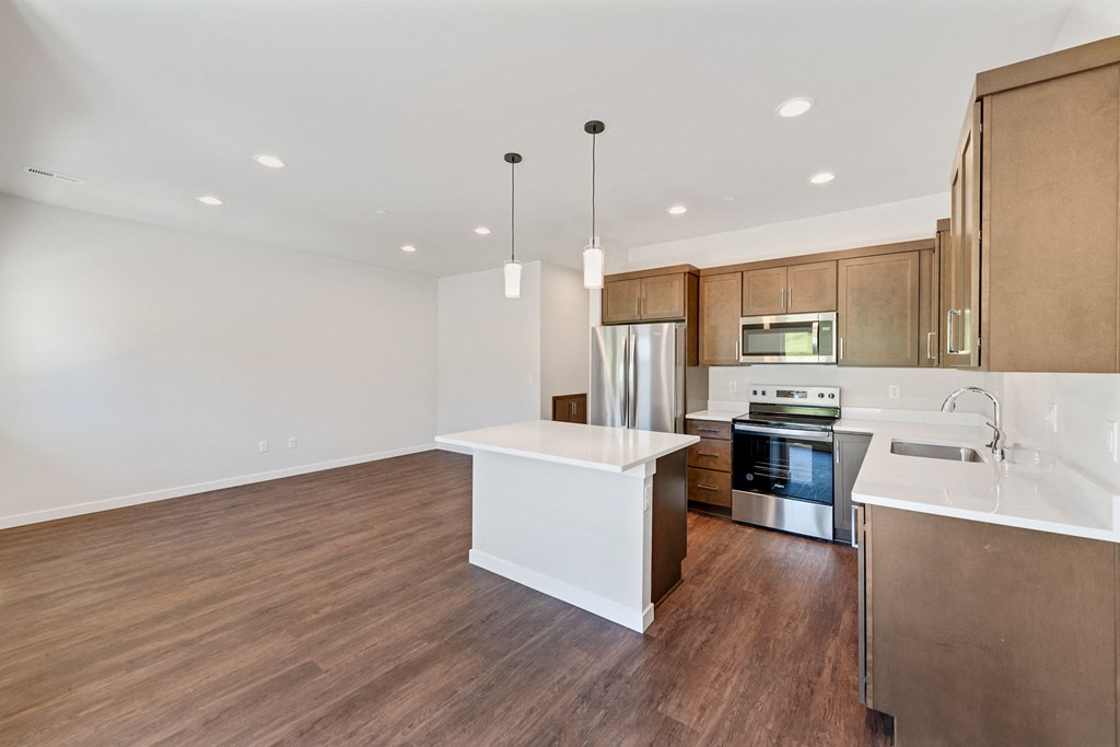 a large kitchen with a white island and stainless steel appliances