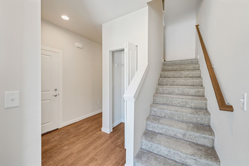 a stairwell in a home with a wood floor and carpeted stairs