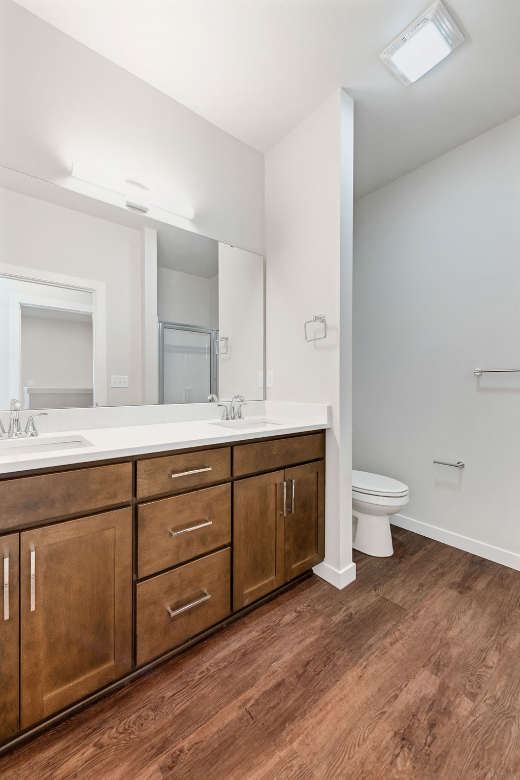 a bathroom with wooden cabinets and a toilet and a sink