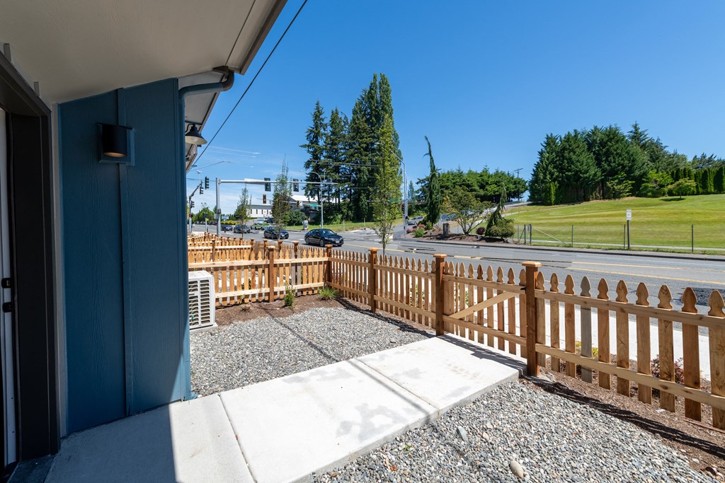 a porch with a fence and a street in front of a house