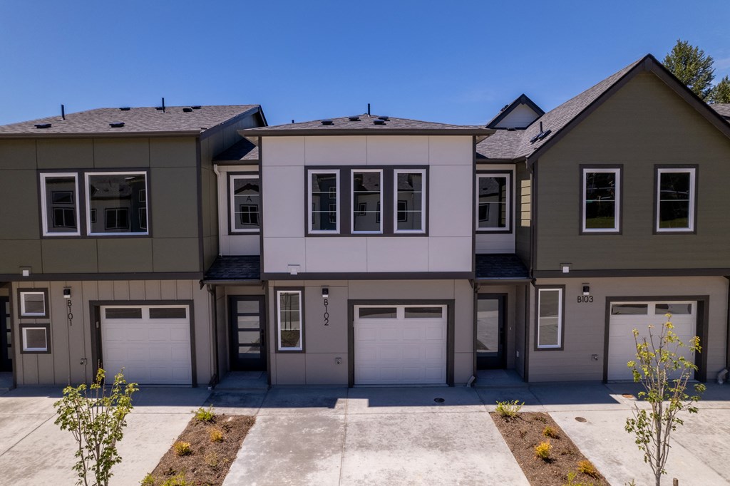 two story house with white and brown walls and garage doors