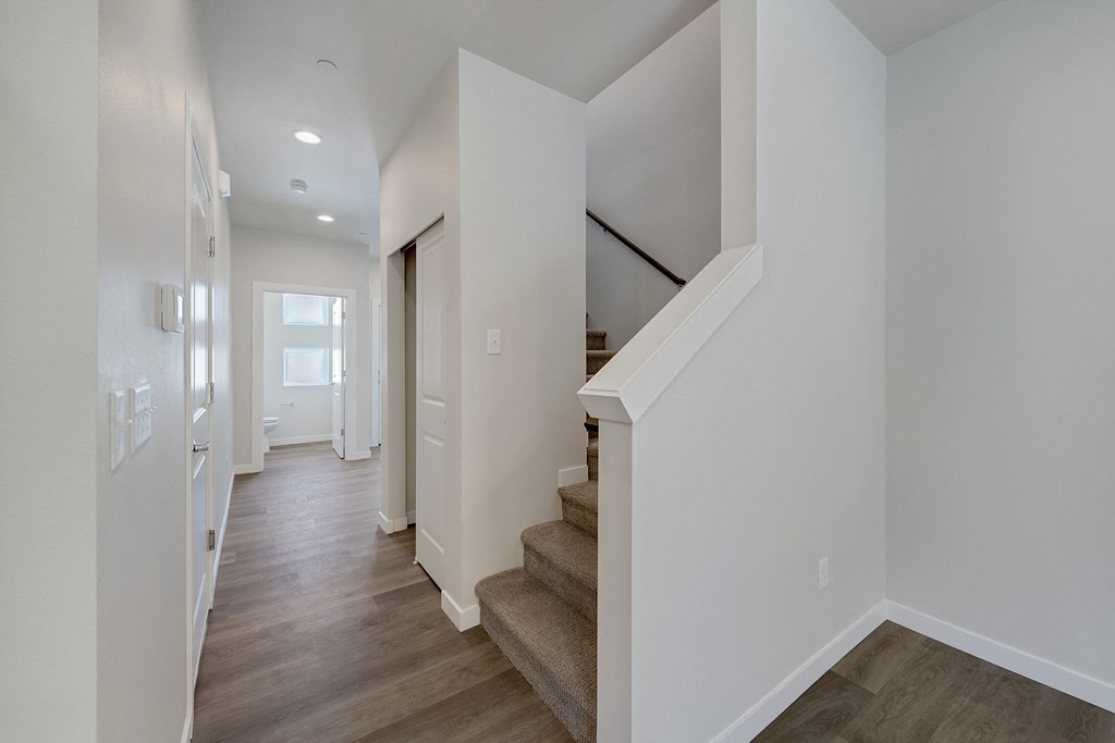 A long hallway with a staircase on the right.