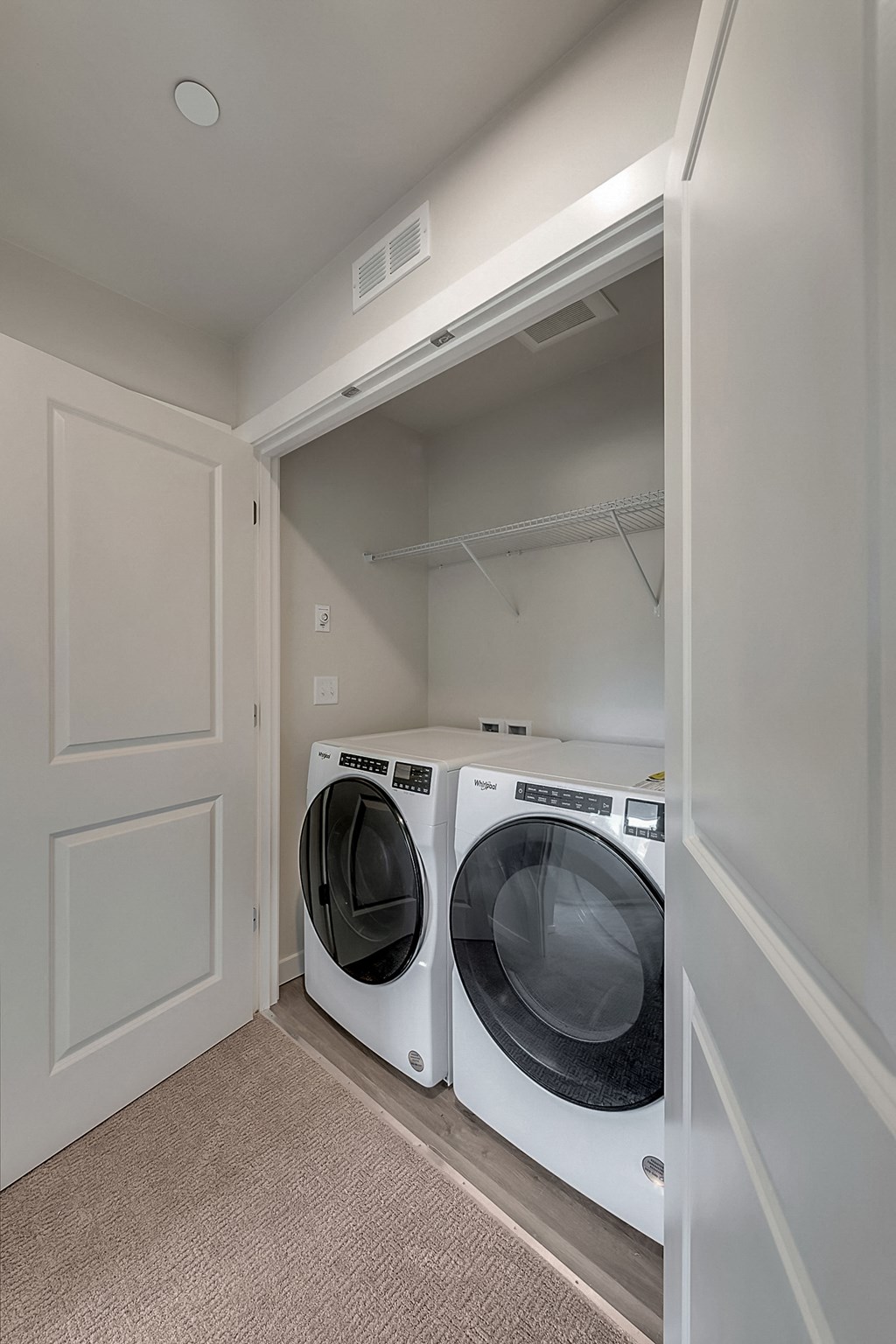 A white dryer is sitting in a laundry room.