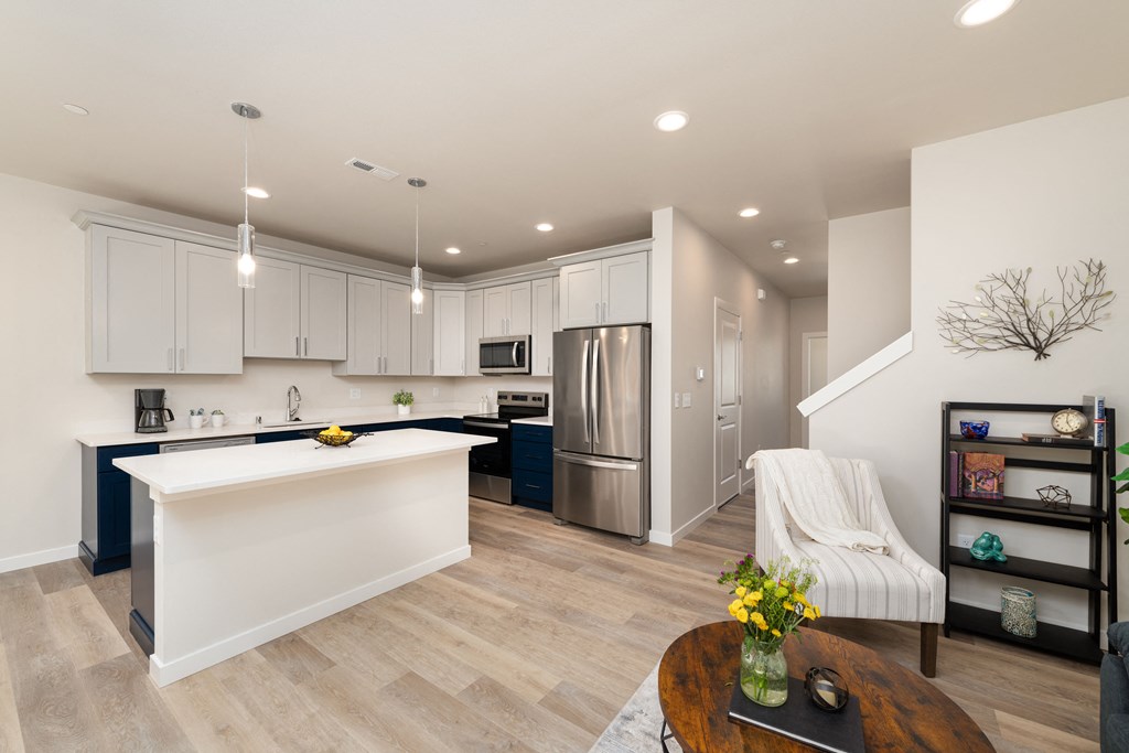 A modern kitchen with a white island and stainless steel appliances.