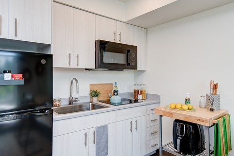 a kitchen with white cabinets and a sink and a microwave