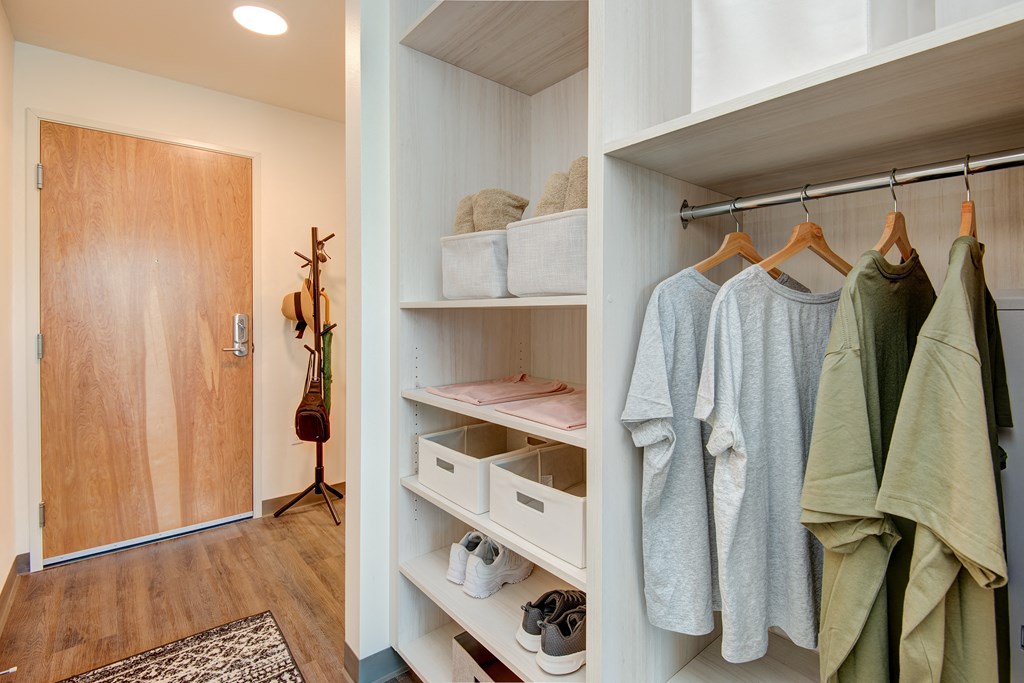 a walk in closet with a door to the bathroom