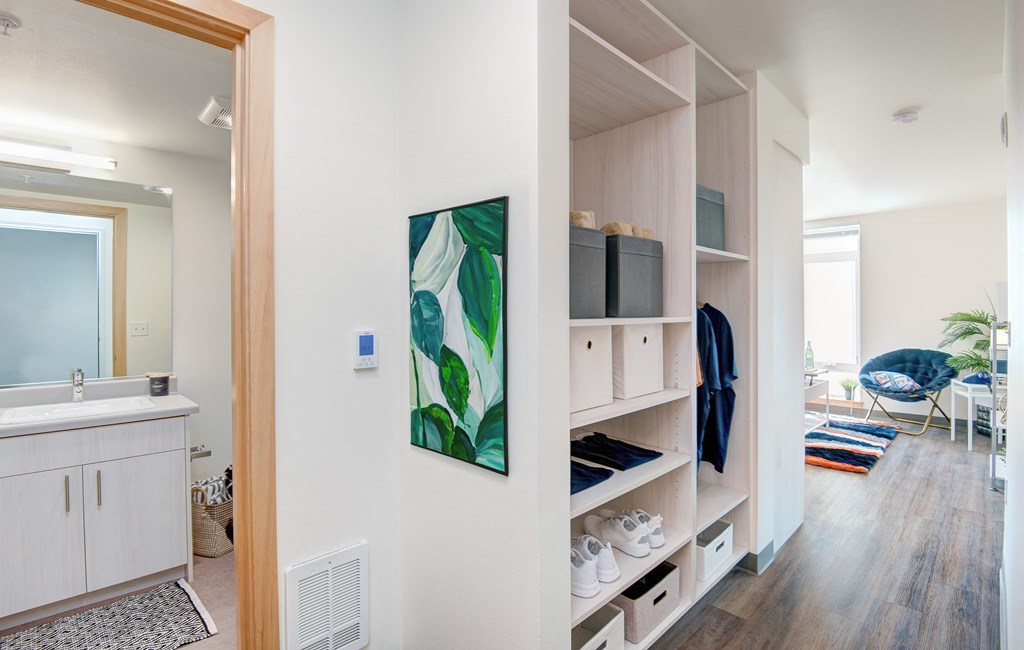 a living room and kitchen with white cabinets and a painting on the wall