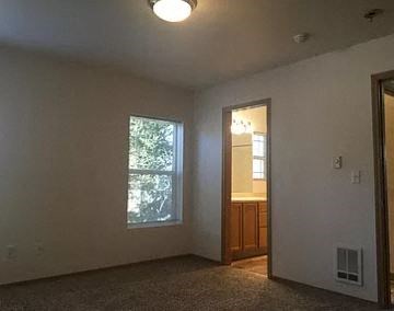 an empty living room with a window and a door