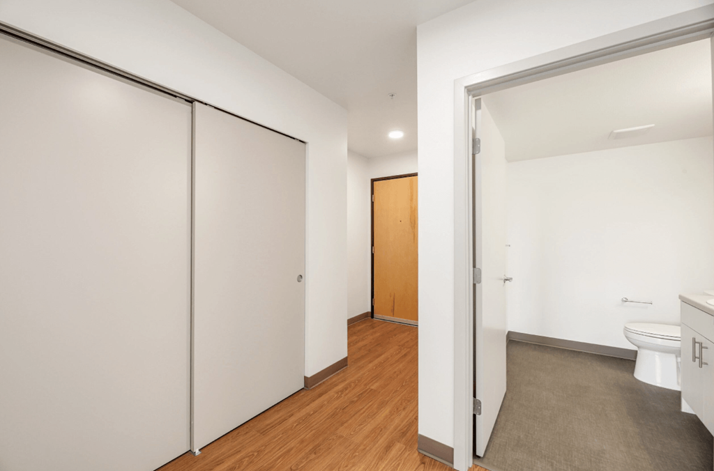 a bedroom with a door to a bathroom and a closet