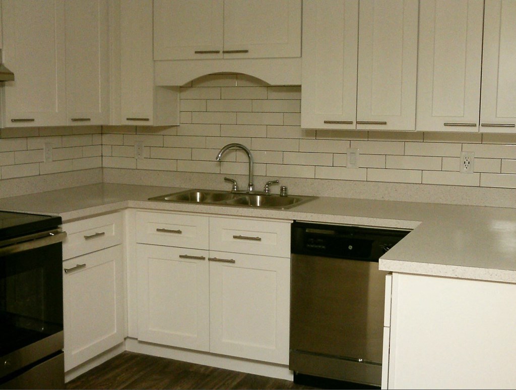 a white kitchen with white cabinets and a sink