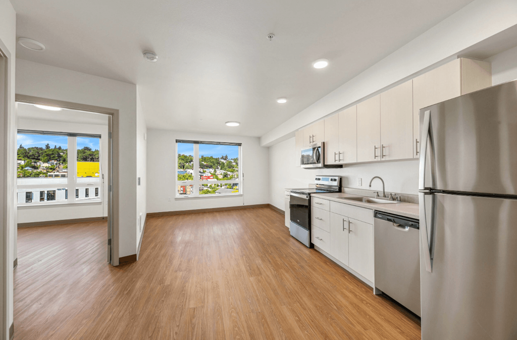 a renovated kitchen with stainless steel appliances and a large window