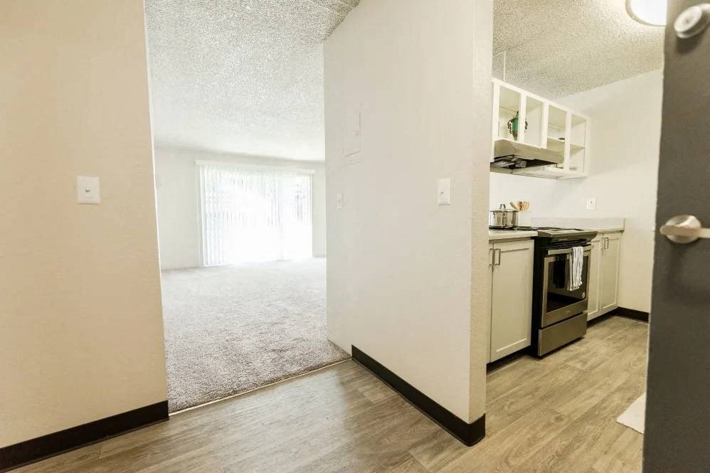 a kitchen and living room with an open door