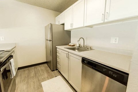 a kitchen with stainless steel appliances and white cabinets