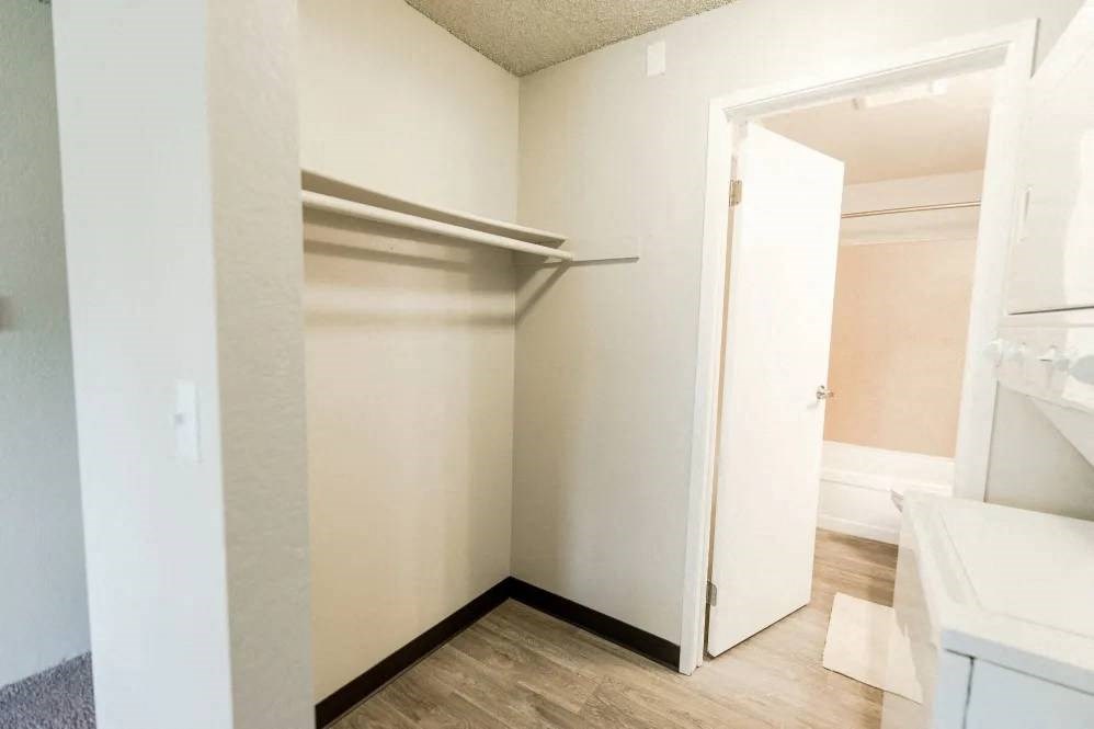 a walk in closet in a bathroom with an open door