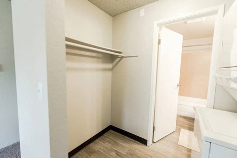 a walk in closet in a bathroom with an open door