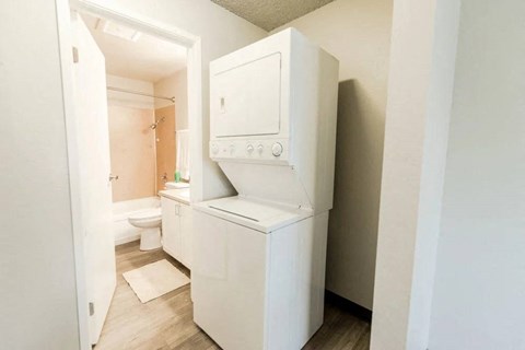 a white washer and dryer in a white bathroom