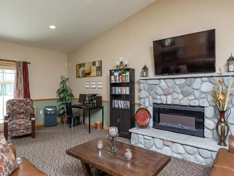 a living room with a stone fireplace and a television