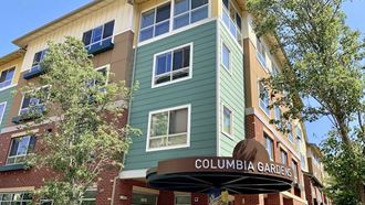 a green apartment building with a columbia garden sign