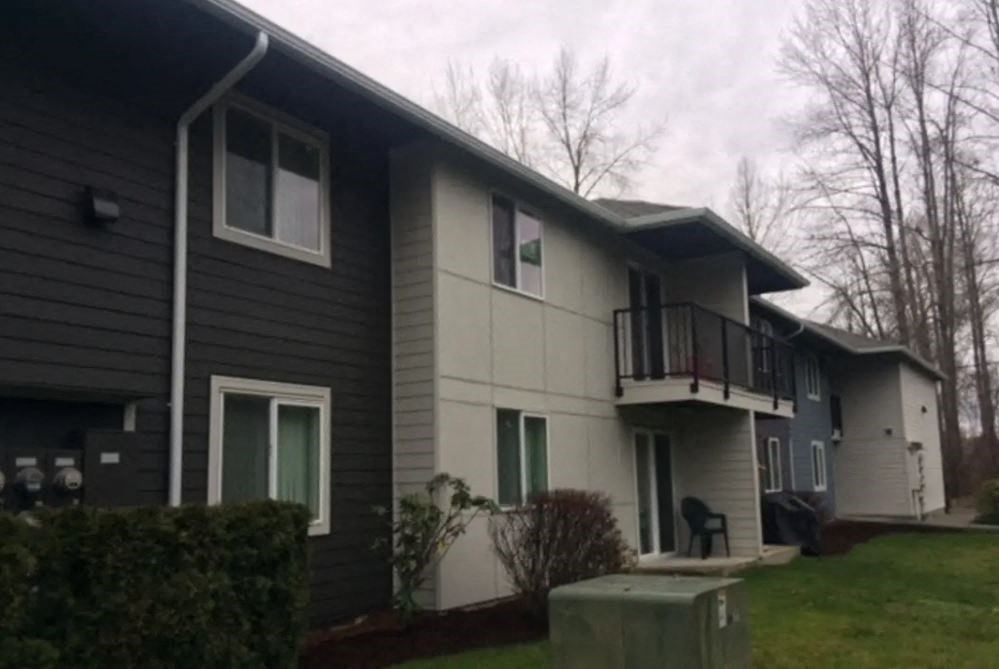 the front of a house with a yard and a balcony