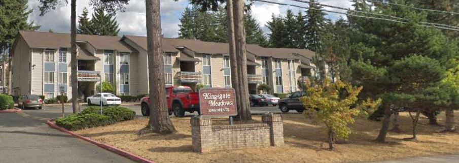 an apartment building with a sign in front of it