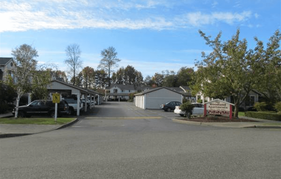 a street of houses with cars parked on the side of the road