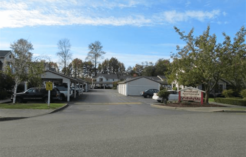 a street of houses with cars parked on the side of the road