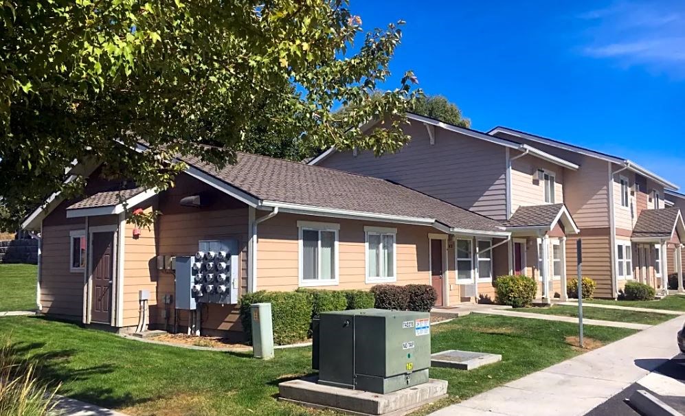 a brown house with a green mailbox in front of it