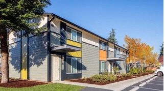 an apartment building with a tree in front of it