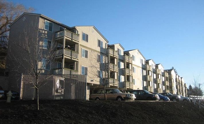 a large apartment building with cars parked in front of it