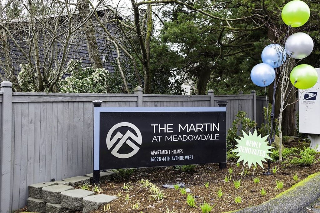 a sign for the at meadowdale in front of a fence