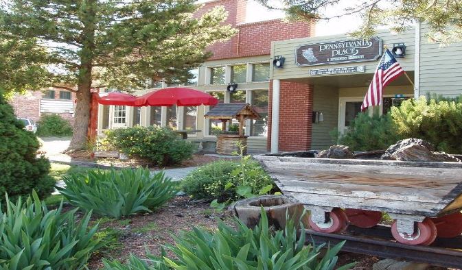 an old boat in a garden in front of a building