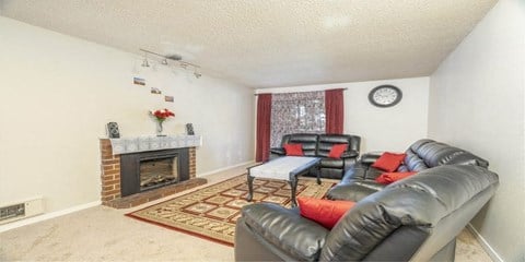 a living room with leather furniture and a fireplace