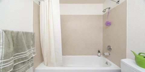 a bathroom with a white bath tub and a towel
