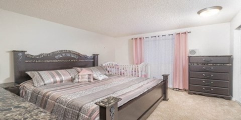 a bedroom with a bed and a baby crib