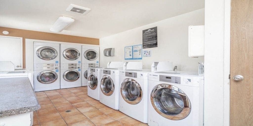 a laundry room with lots of washing machines and dryers