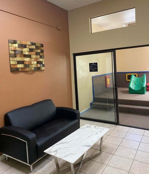 a waiting room with a black chair and a coffee table