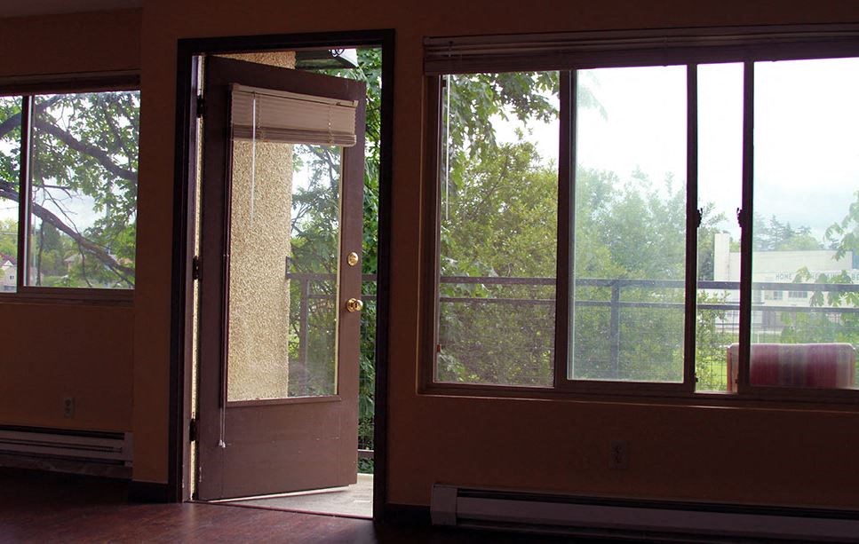 a living room with a door and three windows