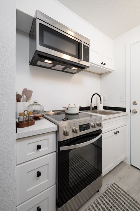 A modern kitchen with a stove top oven and microwave above it.