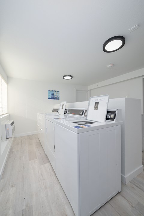 A white kitchen with a fridge, microwave, and oven.