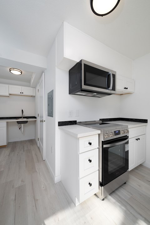 A modern kitchen with a black microwave above the stove.