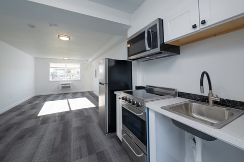 A modern kitchen with a stainless steel refrigerator, oven, and microwave.