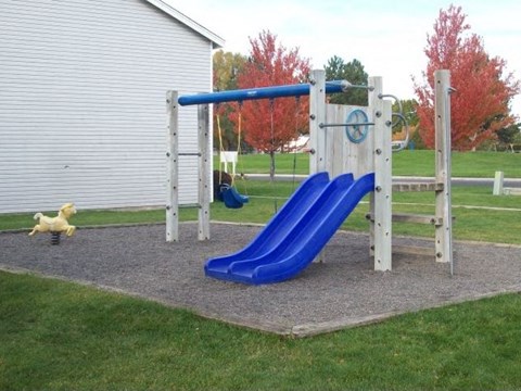 a playground with two slides and a swing set
