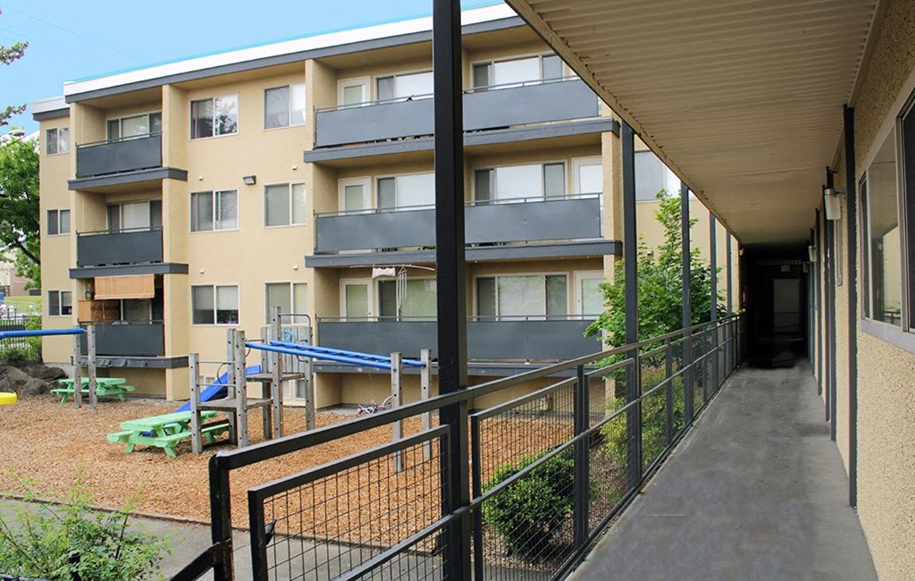the outside of an apartment building with a ramp and a playground
