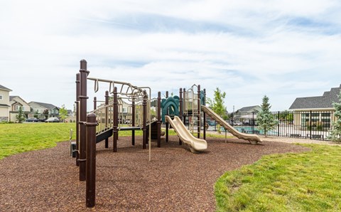 A playground with a slide, swings, and a climbing frame.