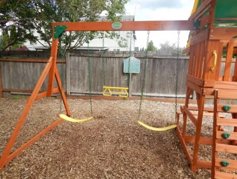 A playground with a swing set and a slide.