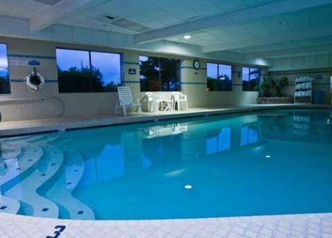a large swimming pool in a room with chairs