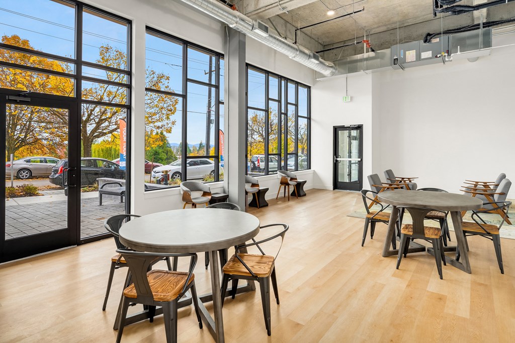 a dining room with tables and chairs and large windows