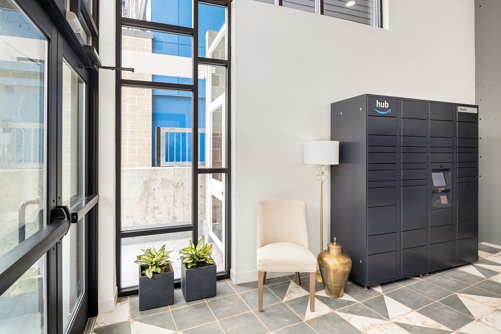 a lobby with a chair and a large black chest of drawers